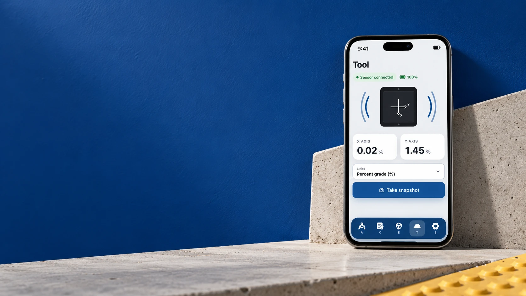 The ADAM Tool screen on a phone beside a concrete step, showing a connected sensor and X and Y axis readings