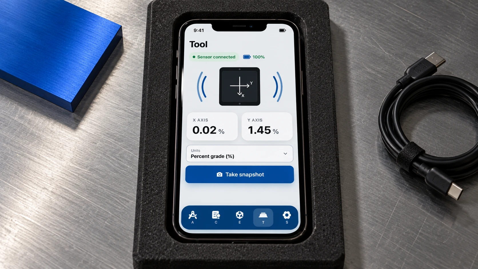 The ADAM Tool screen on a phone in a foam case, showing sensor connected, X and Y axis readings and a Take snapshot button